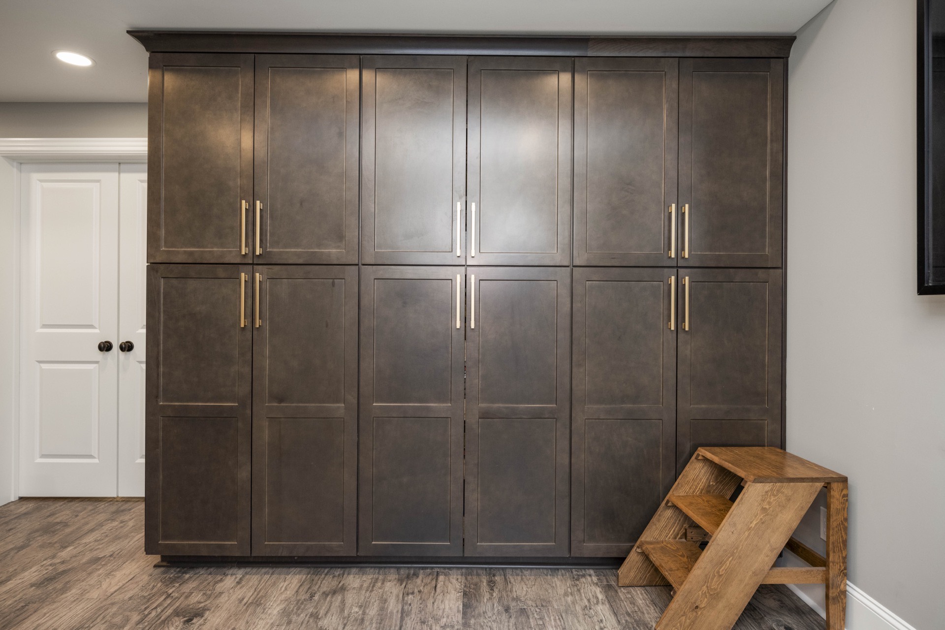 Dark wood floor-to-ceiling cabinetry in a finished basement