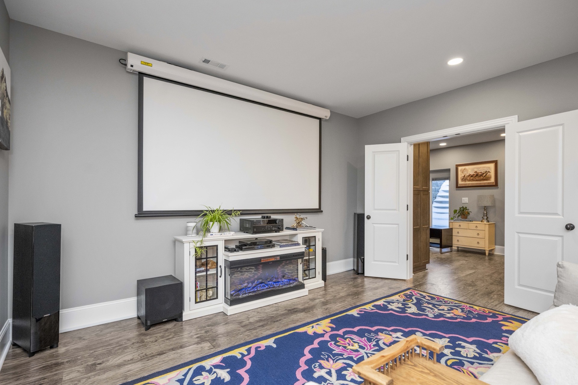 Media wall with projector screen in a Locust Creek basement