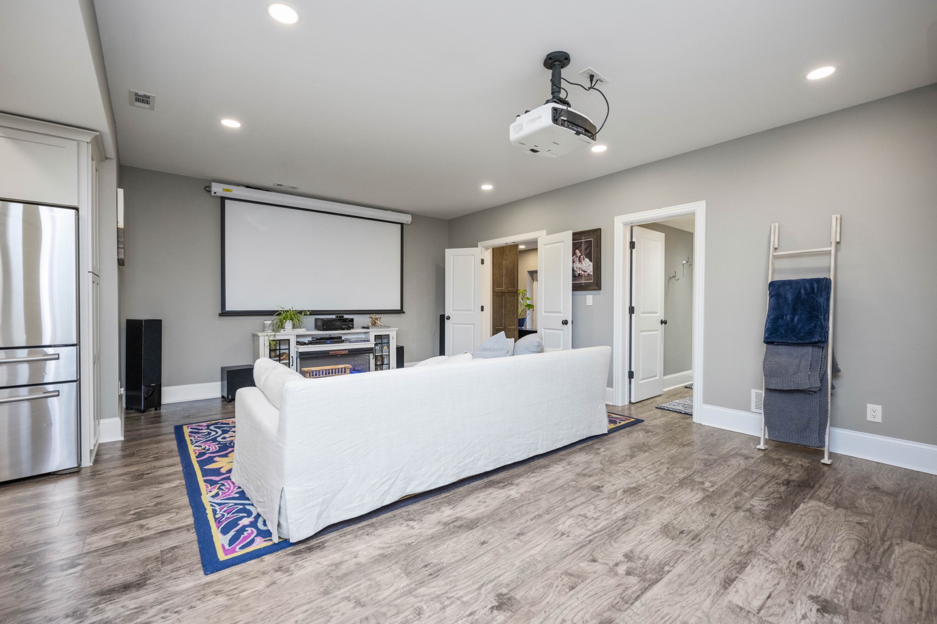 Home theater seating and projector screen in the Locust Creek basement