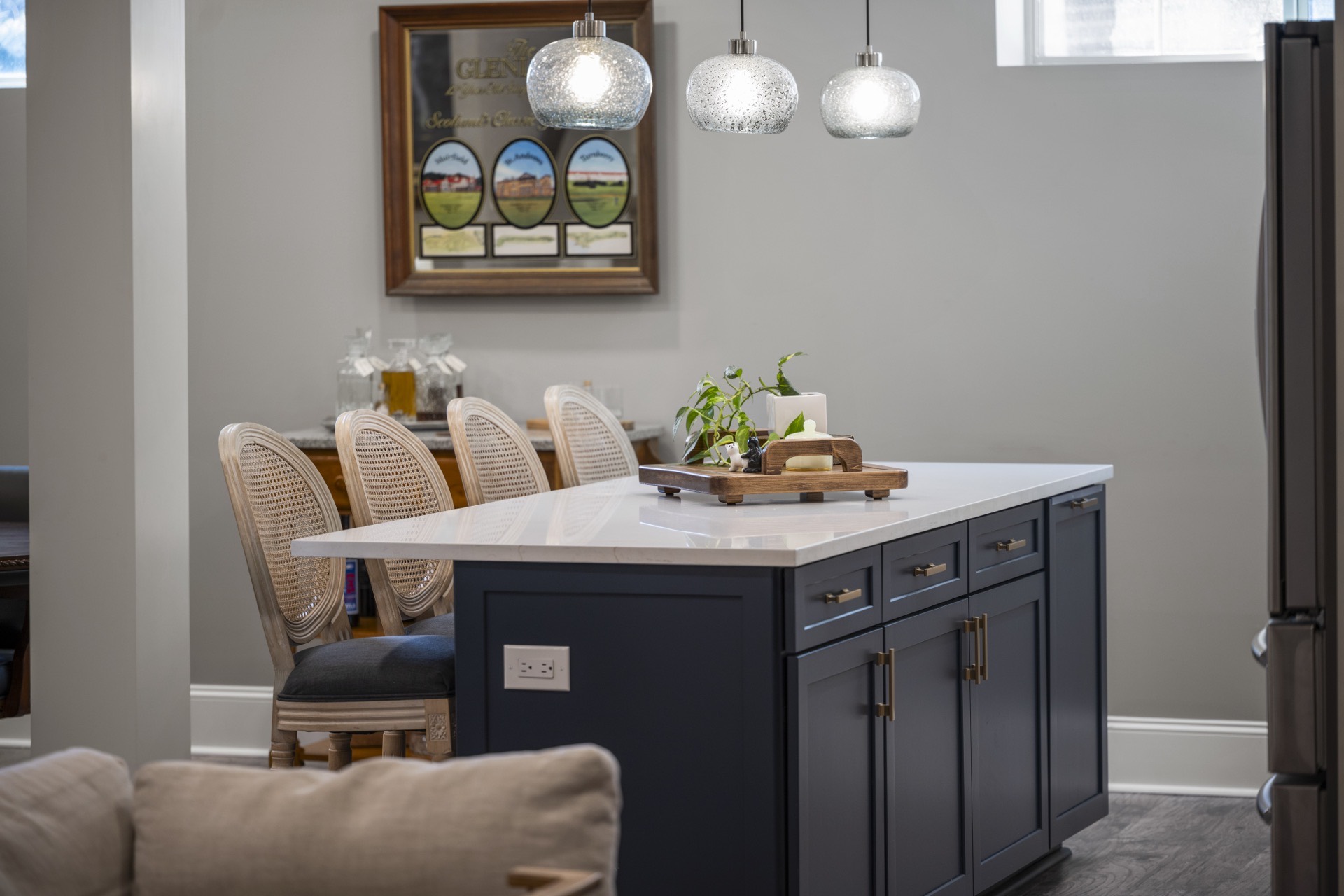 Navy island bar and pendant lights in a finished basement