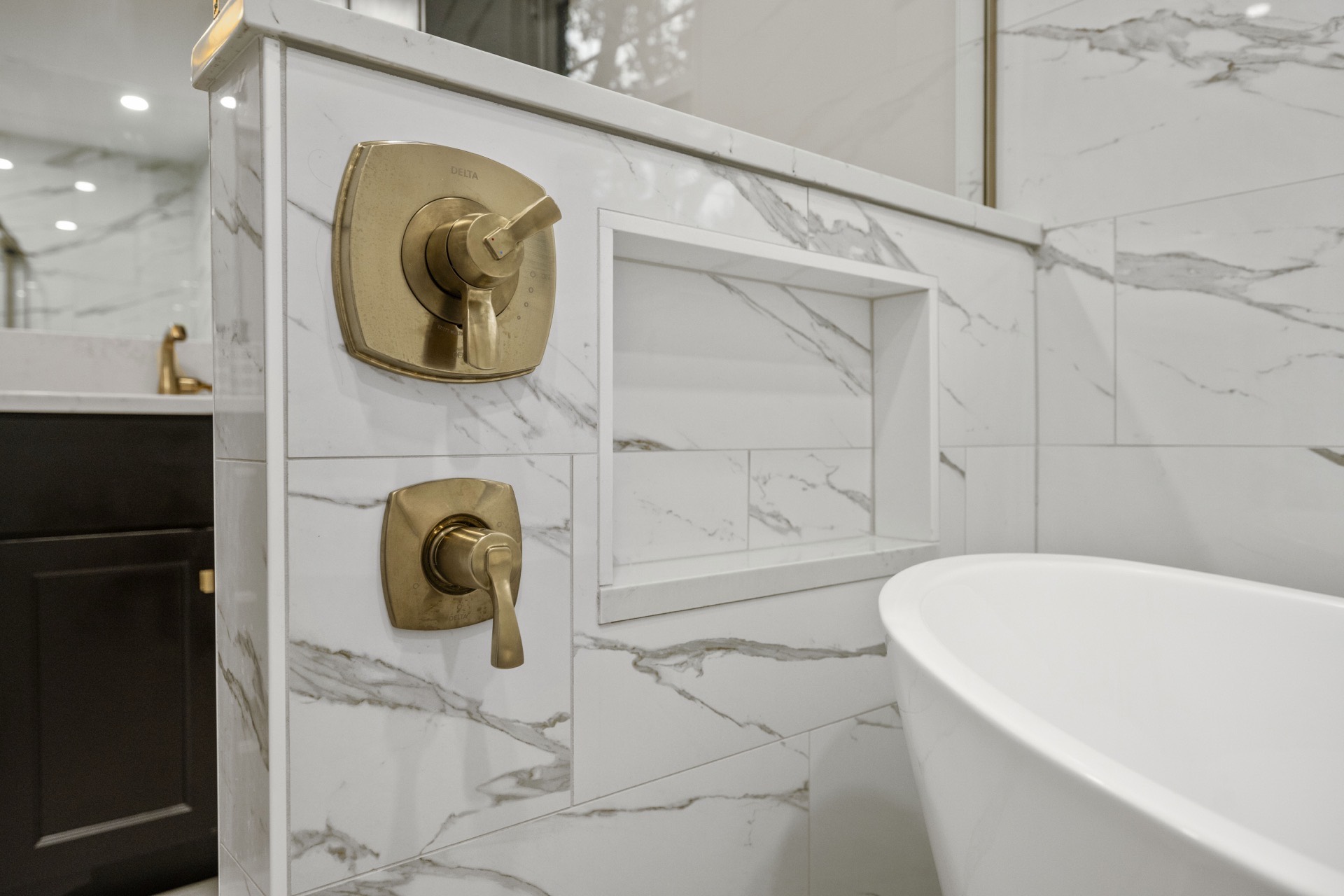 Brass shower controls and marble niche detail at Deer Lake