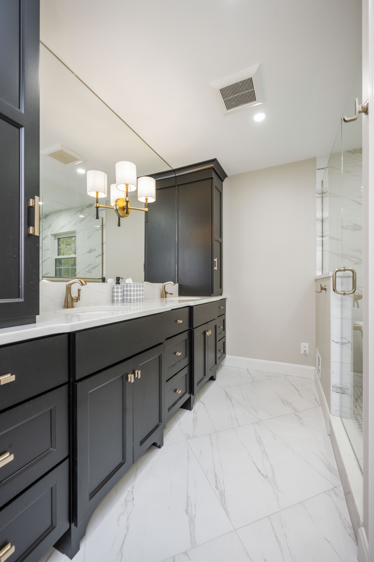 Deer Lake primary bathroom with black vanity and marble floor