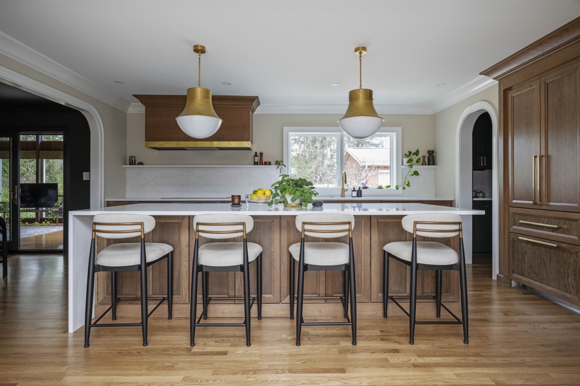 Athenia kitchen with wood island, waterfall stone, and arched openings