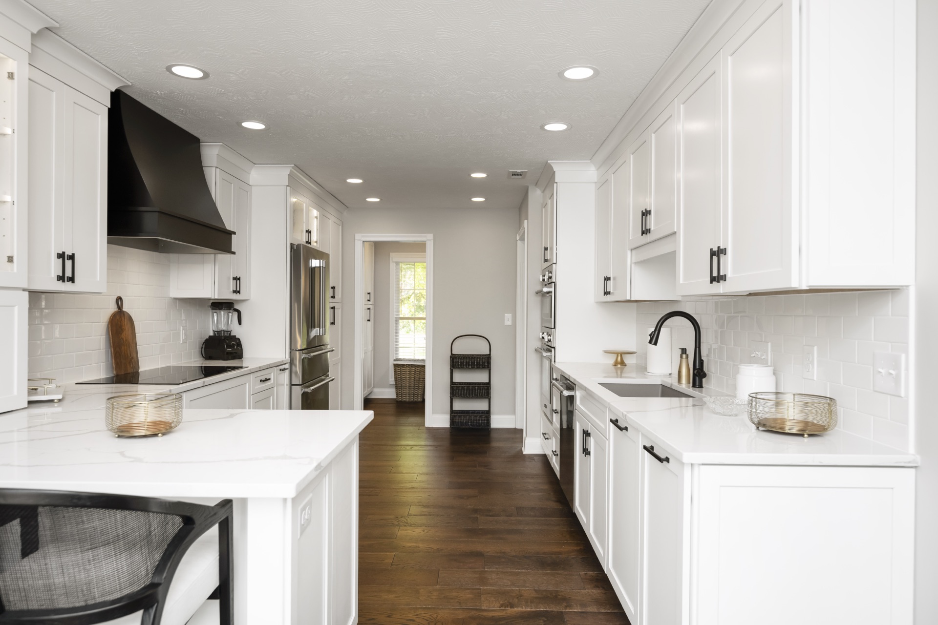Stoneridge Road white kitchen with waterfall marble island and black range hood